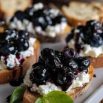 Balsamico Blaubeer Crostinis mit Ziegenkäse auf einem Holzteller