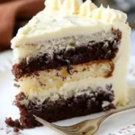 Dekadenter weißer Schichtkuchen mit fudgy Brownie auf einem Teller serviert.