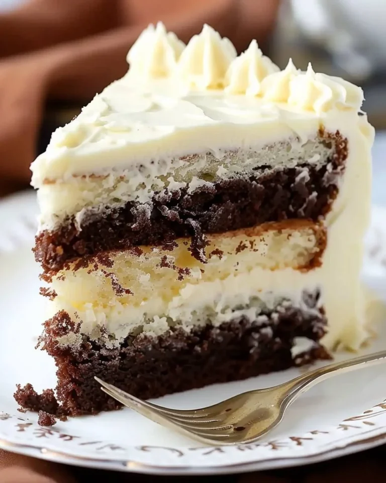 Dekadenter weißer Schichtkuchen mit fudgy Brownie auf einem Teller serviert.