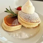 Extra fluffige Soufflé-Pfannkuchen auf einem Teller serviert