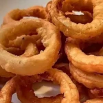 Knusprige Zwiebelringe aus der Luftfritteuse auf einem Teller serviert