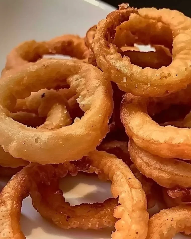 Knusprige Zwiebelringe aus der Luftfritteuse auf einem Teller serviert