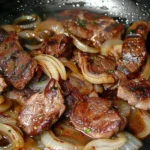 Rinderleber mit Zwiebeln und Weißwein auf einem Teller serviert