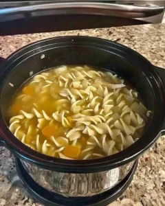 Schüssel mit seelenwärmender Hühnchen-Nudelsuppe auf einem Holztisch