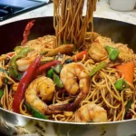 Leckeres Shrimp Lo Mein mit rotem und grünem Pfeffer in einer Pfanne.