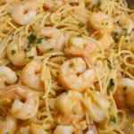 Bang Bang Garnelen Pasta mit würziger Sauce und frischen Kräutern serviert.