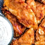 Gebackenes KFC-Huhn serviert auf einem Teller mit Beilagen.