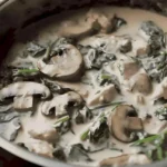 Cremiges Hühnchen mit Spinat und Pilzen in einer Schüssel serviert