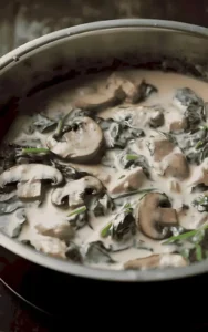 Cremiges Hühnchen mit Spinat und Pilzen in einer Schüssel serviert