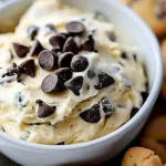 Klassischer Chip-Kokos-Dip in einer Schüssel serviert mit Chips daneben