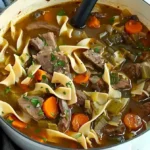 Rindfleischnudelsuppe in einer Schüssel, garniert mit frischen Kräutern.