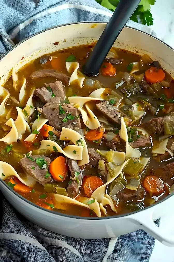 Rindfleischnudelsuppe in einer Schüssel, garniert mit frischen Kräutern.