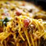 Leckeres Taco-Spaghetti-Gericht mit Käse auf einem Teller