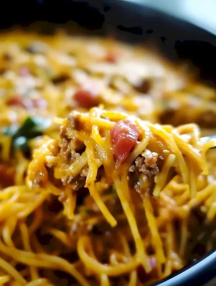 Leckeres Taco-Spaghetti-Gericht mit Käse auf einem Teller