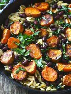 Ultimatives Butternut-Kürbis-Orzo mit Würstchen und Spinat auf einem Teller