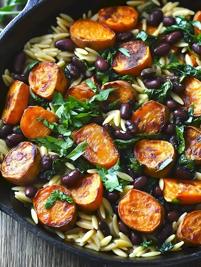 Ultimatives Butternut-Kürbis-Orzo mit Würstchen und Spinat auf einem Teller