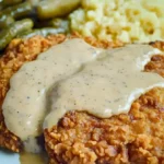 Hähnchen-frittiertes Rindersteak auf einem Teller, serviert mit Beilage.