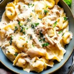 Hähnchen-Tortellini Alfredo in einer cremigen Sauce serviert