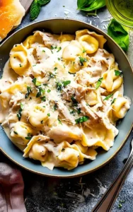 Hähnchen-Tortellini Alfredo in einer cremigen Sauce serviert
