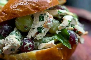 Hühnchen-Salat mit frischen Trauben und Pecannüssen auf einem Teller