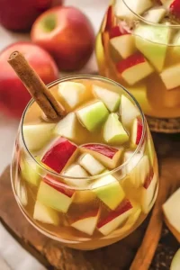 Karamell-Apfel-Sangria in einem Glas, dekoriert mit Apfelscheiben und Karamellsoße.
