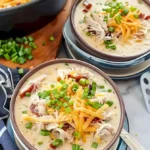 Schüssel mit knuspriger Hühnersuppe, garniert mit frischen Kräutern.