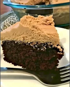 Schokoladen-Erdnussbutter-Verrückter Kuchen auf einem Teller dekoriert mit Erdnüssen.