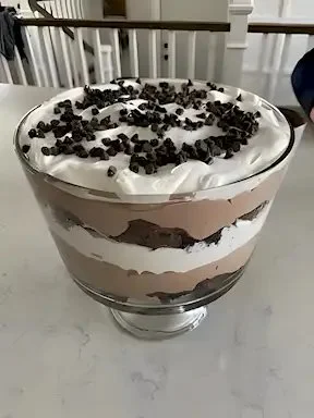 Schokoladen Trifle mit Schichten aus Schokolade, Sahne und Keksen in einem Glas serviert.