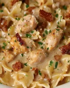 Farfalle mit Hähnchen und geröstetem Knoblauch auf einem Teller serviert