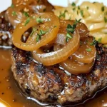 Leckeres Hamburger Steak mit Zwiebelfondue auf einem Teller serviert