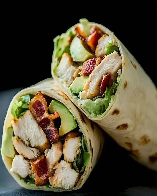 Klassisch gebratener Hähnchen Wrap mit Avocado und Dijon-Sauce auf einem Teller