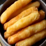 Luftige chinesische Frittierstäbchen mit weichem Kern auf einem Teller.