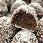 Schokoladen-Schneeballplätzchen auf einem Teller dekoriert mit Puderzucker