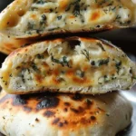 Weiches gefülltes Brot mit Mozzarella und Spinat auf einem Holztisch